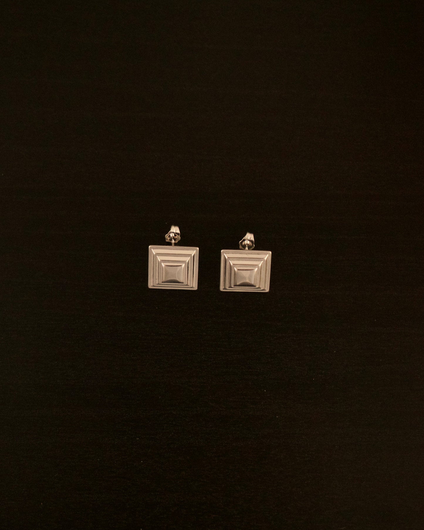 SIENTE PETITE silver earrings – close-up of minimalist square silver earrings with a modern sculptural design.