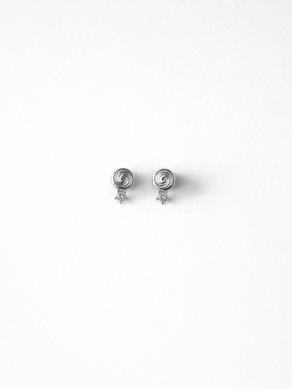 Cold Edges Alba silver spiral stud earrings with a small stone, on a white background