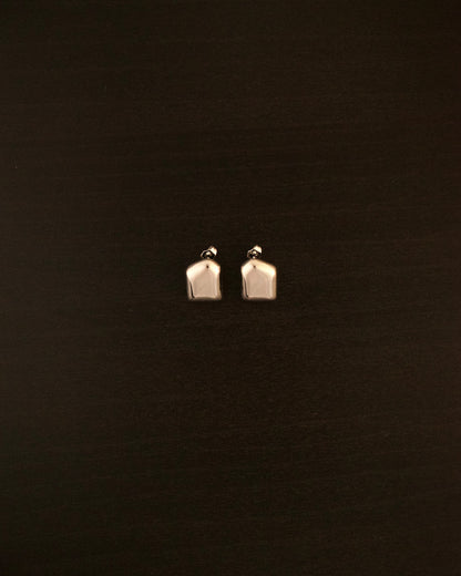 AURA PETITE silver earrings – close-up of sculptural, fluid-shaped minimalist earrings in polished silver.