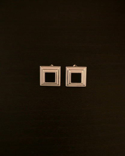 Black Panther earrings – close-up of square silver earrings with a black onyx stone, bold and minimalist design.