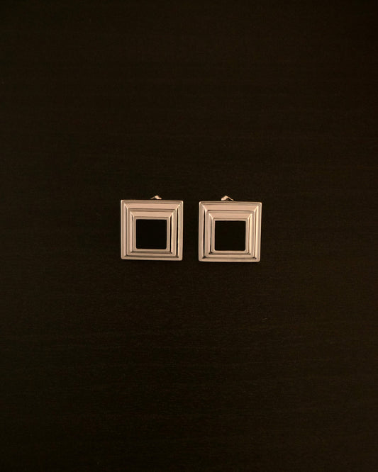 Black Panther earrings – close-up of square silver earrings with a black onyx stone, bold and minimalist design.