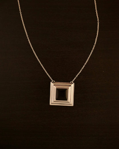 Black Panther necklace – close-up of square silver pendant with a black onyx stone at the center, bold and minimalist.