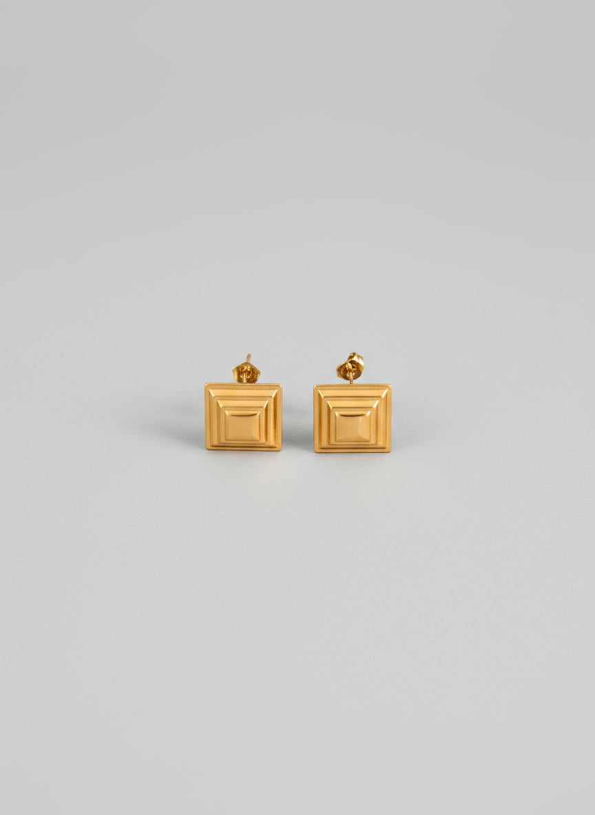 Pair of gold square earrings on a white background