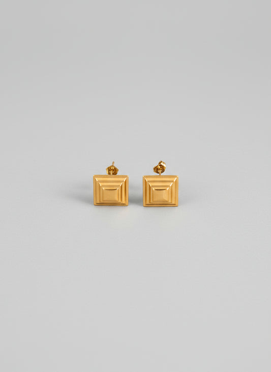 Pair of gold square earrings on a white background