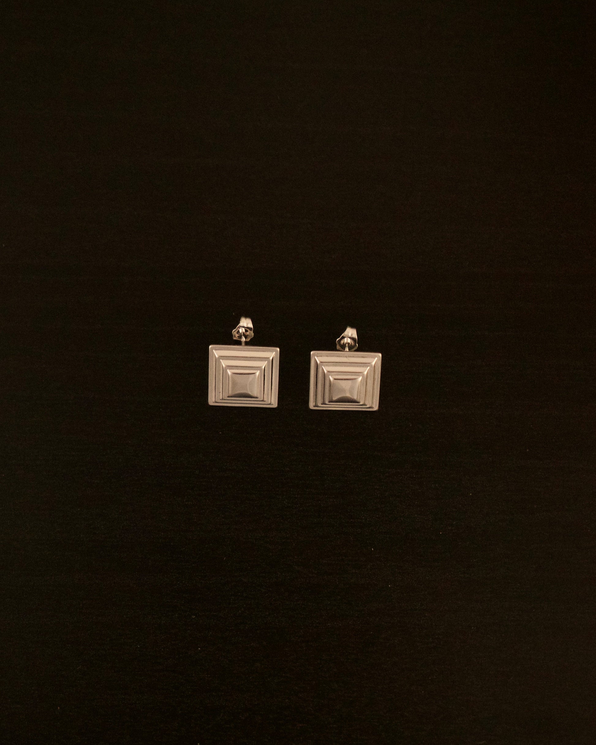 SIENTE PETITE silver earrings – close-up of minimalist square silver earrings with a modern sculptural design.