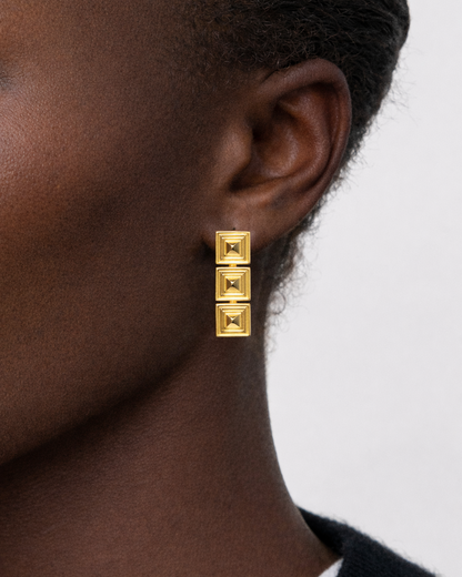 gold hanging earrings art deco vibe on a model in a studio